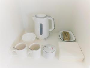 a counter with a coffee maker and cups on it at Railway Avenue Rooms in Clifden