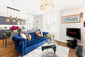 a living room with a blue couch and a table at The Shirt Factory Apartments in Warrington