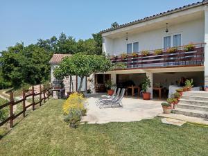 a house with two chairs in a yard with a fence at B&B "Retro Gusto " in Pićan