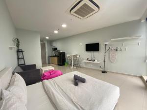 a living room with a white couch and a tv at Pinnacle PJ @ Penguin Homes in Petaling Jaya