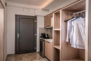 uma cozinha com armários de madeira e uma porta num quarto em Crete Resort Sea Side Suites "Adults Only" by Checkin em Gouves