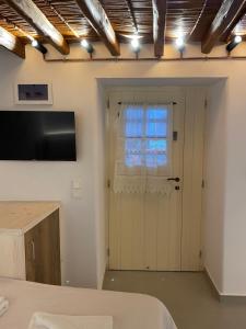 una camera con una porta con televisore e finestra di Cozy apartment Kostos a Kóstos