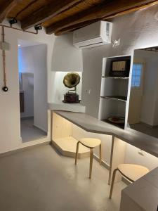 una cucina con tavolo e due sgabelli in una stanza di Cozy apartment Kostos a Kóstos