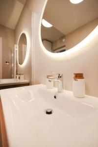 a bathroom with a white sink and a mirror at Apartments Mila M in Sveti Filip i Jakov