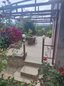 a patio with a bunch of flowers and a table at Vila Tatiana in Bîc