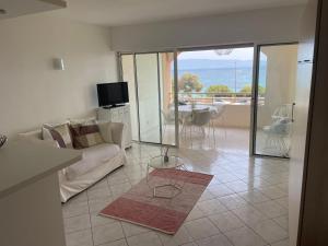 - un salon avec un canapé et une table avec vue dans l'établissement Superbe Pieds dans l eau ajaccio face à la mer plage de sable fin route des îles des sanguinaires, à Ajaccio