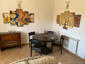 uma sala de jantar com mesa, cadeiras e pinturas em Villetta Tranquilla em Agrigento