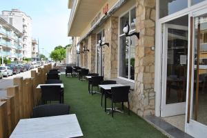 a row of tables and chairs on the side of a building at Hotel Bell Aire in L'Estartit