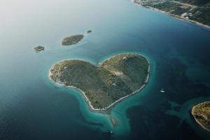 an island in the shape of a heart in the water at Apartments Mila M in Sveti Filip i Jakov