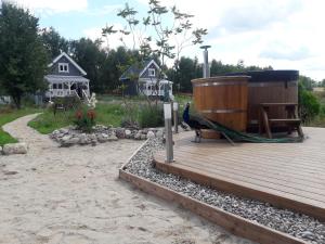 a peacock sitting on a wooden deck with houses in the background at OSTOJA PAWIE OKO in Potęgowo