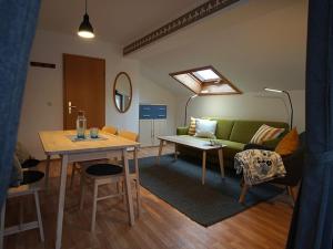 ein Wohnzimmer mit einem grünen Sofa und einem Tisch in der Unterkunft Gästehaus Math in Oberstdorf