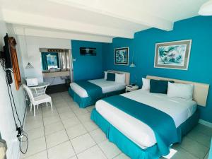 um quarto azul com duas camas e uma mesa em Big Pine Key Motel em Big Pine Key