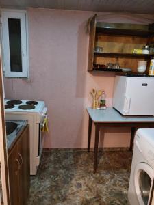 a kitchen with a stove and a table with a microwave at Bombora in Mestia