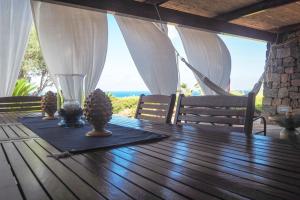 a wooden table with a glass vase on top of it at iFlat Dammusi Thienzo in Pantelleria