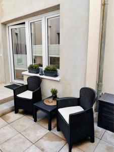 un patio con 3 sillas, una mesa y una ventana en Pension Alabama, en Warnemünde