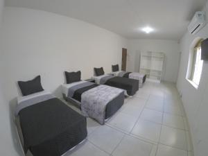 Zimmer mit 4 Betten in einem Zimmer mit Fenster in der Unterkunft Quartos Delfim Moreira in Varginha