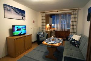 a living room with a couch and a tv at Gästehaus Math in Oberstdorf