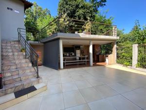 een huis met een balkon en een patio bij Grey House in Foz do Iguaçu