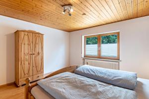 a bedroom with a bed and a wooden ceiling at Haus Weber in Hölzberg