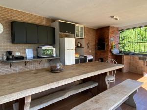a kitchen with a large wooden table with two benches at Grey House in Foz do Iguaçu