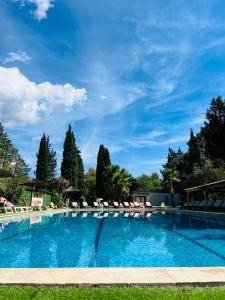 una gran piscina con sillas y sombrillas en Le Chalet de Louise 7 places, en Taradeau