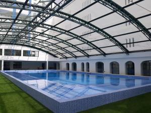 a large indoor swimming pool with a glass roof at Hotel Navegadores in Monte Gordo