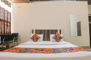 1 dormitorio con 1 cama blanca grande con almohadas coloridas en FabExpress HC King, en Mohali