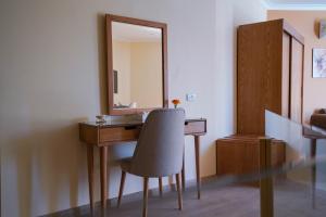a bathroom with a desk with a mirror and a chair at Obelisk Nile Hotel Aswan in Aswan