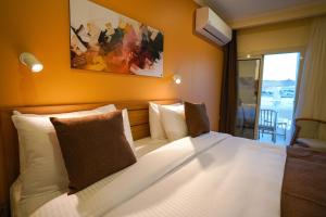 um quarto com uma cama grande e almofadas brancas em Obelisk Nile Hotel Aswan em Aswan