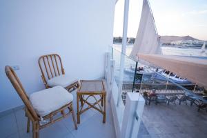 einen Balkon mit 2 Stühlen und einem Segelboot in der Unterkunft Obelisk Nile Hotel Aswan in Assuan