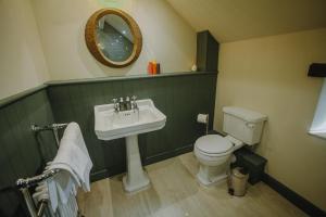 a bathroom with a sink and a toilet and a mirror at Vicarage Farm Cottages in Tideswell