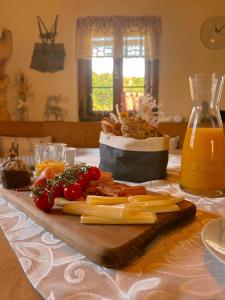 a table with cheese and vegetables on a cutting board at Romantisches Wellness Chalet im steirischen Ursprung 