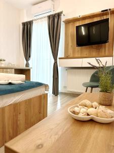 een kamer met een bed en een tafel met een kom brood bij Victory Luxury Apartments in Eforie Nord