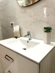 bagno con lavandino bianco e specchio di Victory Luxury Apartments a Eforie Nord