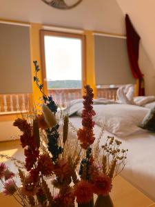 a bedroom with a bed and a table with flowers at Romantisches Wellness Chalet im steirischen Ursprung 