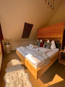 a bedroom with a large wooden bed with a rug at Romantisches Wellness Chalet im steirischen Ursprung 