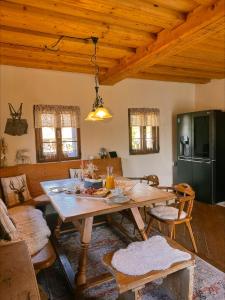 a living room with a wooden table and a kitchen at Romantisches Wellness Chalet im steirischen Ursprung 