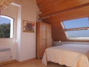 a bedroom with a bed and two windows at Maison Locmaria, 4 pièces, 6 personnes - FR-1-418-67 in Locmaria