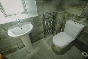 a bathroom with a white toilet and a sink at Vicarage Farm Cottages in Tideswell