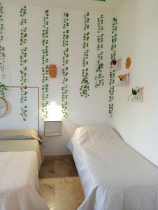 2 camas en una habitación con plantas en la pared en Casa Vacanze I Tre Girasoli "Green House", en Caltagirone