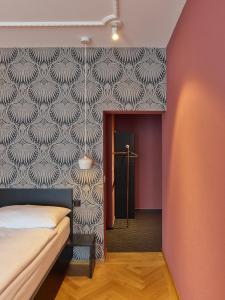 a bedroom with a bed and a wall at ADLER Boutique Hotel in Murten