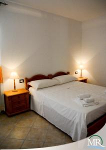 een slaapkamer met een groot bed en 2 lampen op tafels bij Residence Hotel Monte Ricciu in Alghero