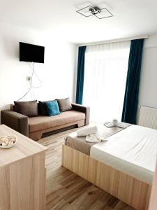 een woonkamer met een bed en een bank bij Victory Luxury Apartments in Eforie Nord