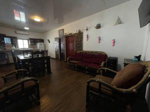sala de estar con 2 sillas y sofá rojo en Casa Elohim, en Iztapa