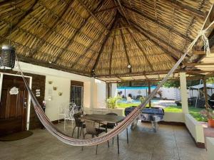 a hammock in a patio with a table and chairs at Casa Elohim in Iztapa