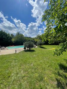 a green park with a swimming pool and trees at Domaine du Bonheur en Pierre avec Piscine, Proche Sarlat in Carlux