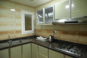 uma cozinha com um lavatório, um fogão e armários em Regency Al Mansoor em Salalah mais 35 fotografias