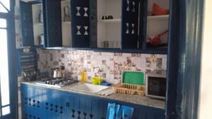 cocina azul con fregadero y fogones en Soultana 4 pour les familles, en Oualidia