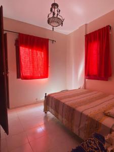 a bedroom with red curtains and a bed at Dar Saada Imm. 5 in Marrakesh