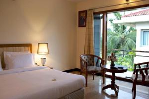 a bedroom with a bed and a window and a table at Sunray Village Resort in Bhogāpuram